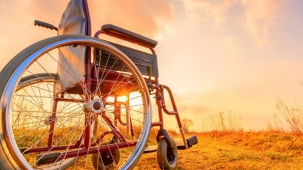 Empty wheelchair on the meadow at sunset. Miracle concept. Healed person raised and went away